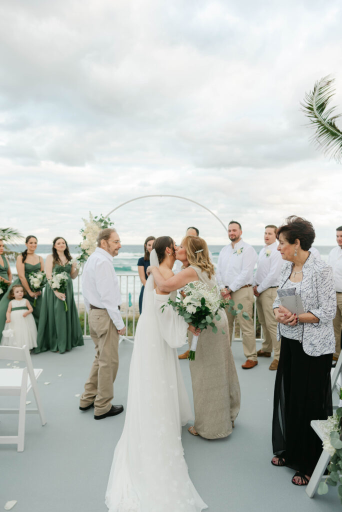 Mother kissing bride at Boca Highland Beach Club
