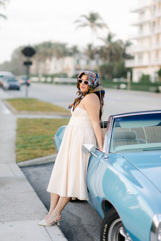 woman waiting beside her vintage car in palm beach