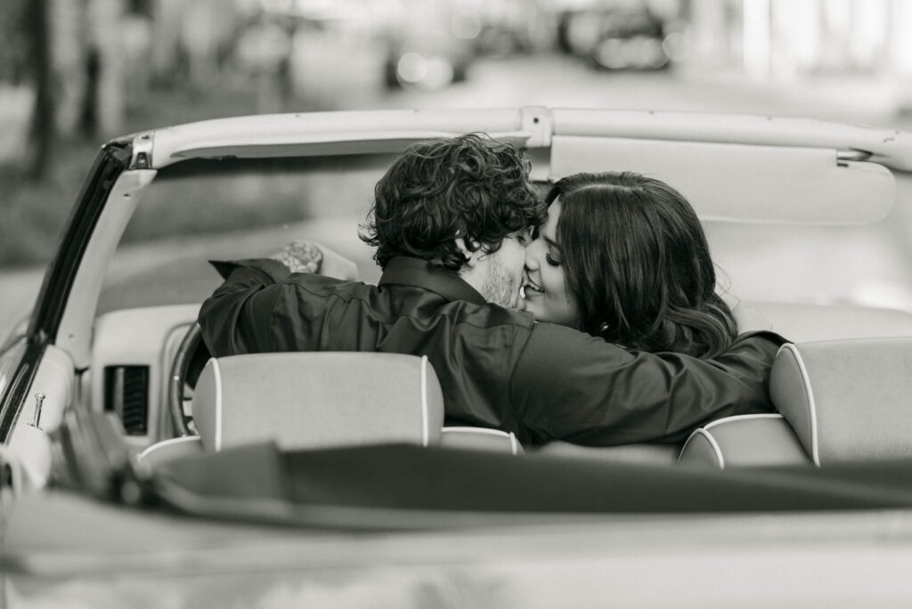 Couple kissing in vintage convertible on Worth Avenue