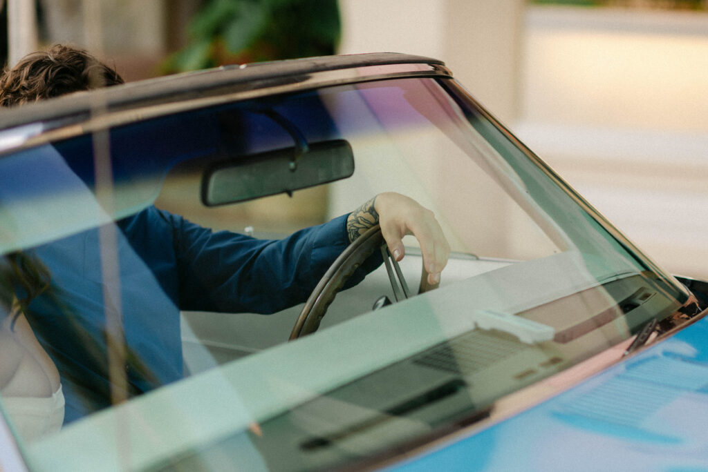 aaron's hand draped over the steering wheel