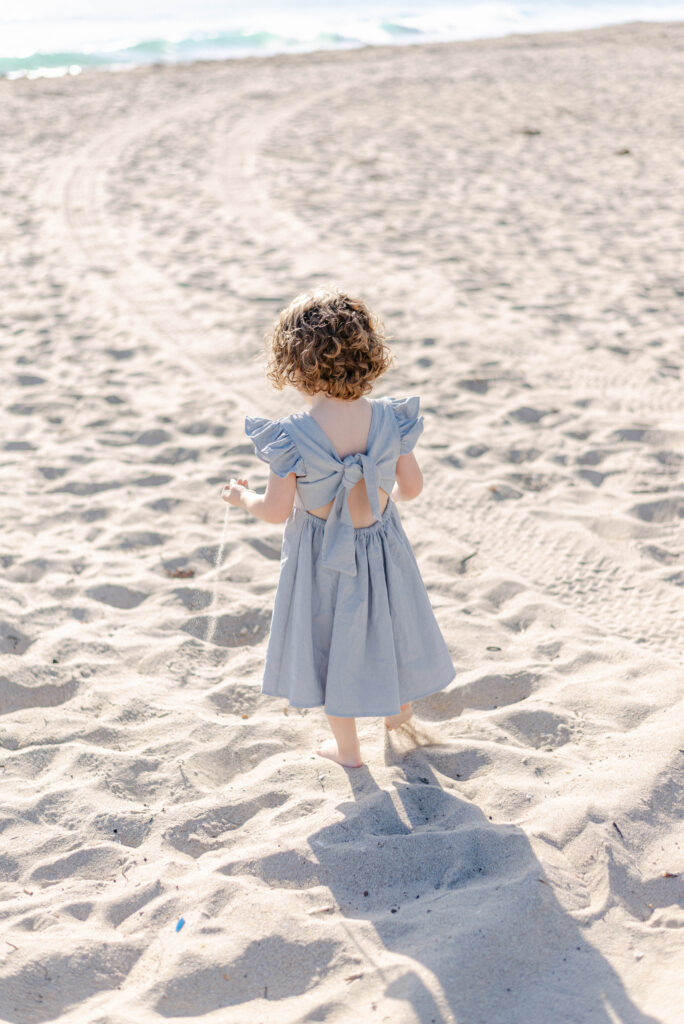 Young girl standing on the sand during a palm beach family session