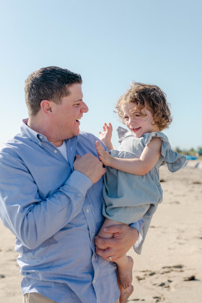Natural family portraits by the ocean with blue skies