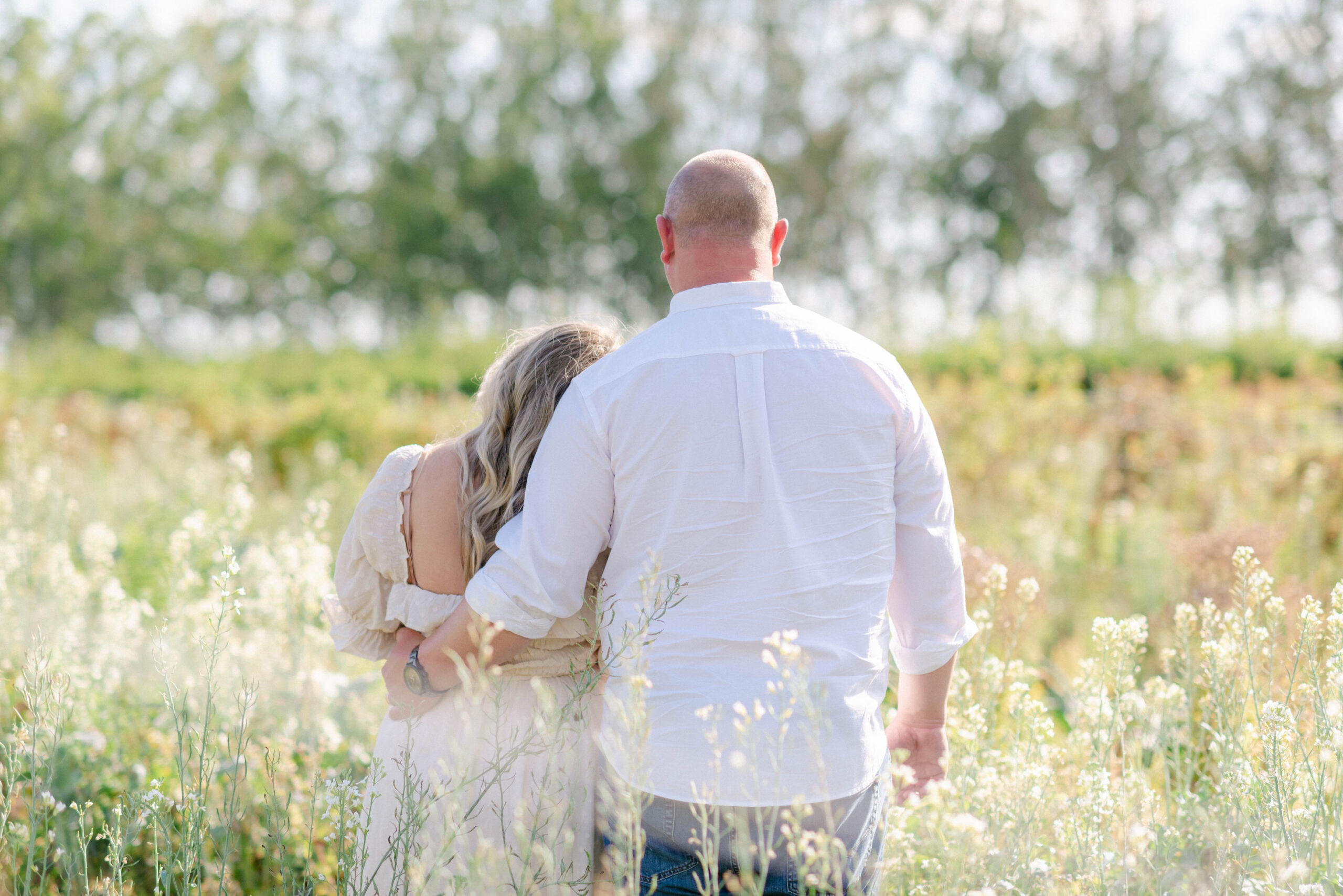 Pregnant couple walking through Kai-Kai Farm field at sunrise in South Florida